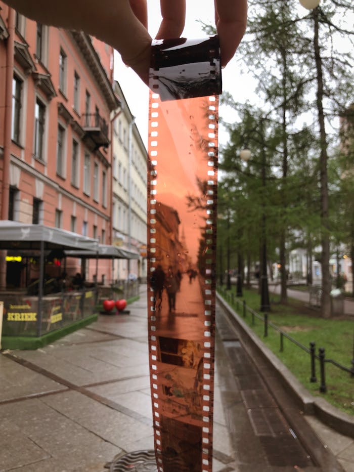 A film negative is held against the street view in Sankt-Peterburg, capturing a unique perspective.